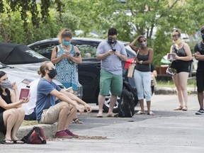 People wait to be tested for COVID-19 at a mobile testing clinic in Montreal, Thursday, July 16, 2020, as the COVID-19 pandemic continues in Canada and around the world.
