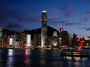 A Star Ferry boat crosses Victoria Harbour in front of a skyline of buildings during sunset, as a meeting on national security legislation takes place in Hong Kong, China June 29, 2020.