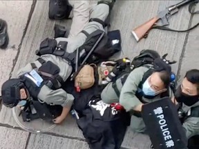 Police detain a motorcyclist who crashed into police officers in Wan Chai near Gloucester Road in Hong Kong on July 1, 2020, in this still image taken from video.