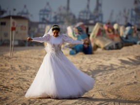 A bride walks on the shore of the Mediterranean Sea before her wedding in Ashdod, Israel July 6, 2020.