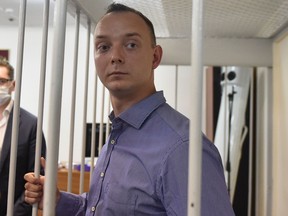 Ivan Safronov, a former journalist and aide to the head of Russia's space agency Roscosmos, detained on charges of treason for divulging state military secrets, stands inside a defendants' cage during a court hearing in Moscow on July 7, 2020.