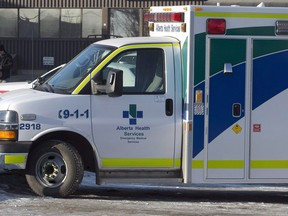 An ambulance waits at the scene as police investigate at a warehouse in Edmonton, on Friday, February 28, 2014. A hospital in west Edmonton has new restrictions in place as the number of COVID-19 cases continues to grow.