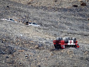 RCMP attend the scene of a sightseeing bus rollover at the Columbia Icefields near Jasper, Alta., Sunday, July 19, 2020. Three people were killed and more than a dozen others were critically injured when a glacier sightseeing bus rolled at one of the most popular attractions in the Rocky Mountains, the Columbia Icefield. RCMP said the rollover happened early Saturday afternoon. Pictures posted online by people at the scene showed one of the attraction's big-wheeled ice explorers on its roof down a moraine embankment.