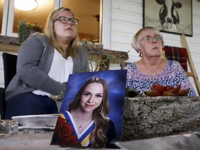 Heather Thomson, right, and her granddaughter Jillisa Thomson speak about their experiences during the Pine Lake tornado as A 2018 graduation photo of "miracle baby" Ashley Thomson at their home near Pine Lake, Alta., Sunday, July 12, 2020. Twenty years after a tornado swept through a campground at a scenic tree-lined lake in central Alberta, killing a dozen people and turning trailers into kindling, Heather Thomson has a pocketful of miracles to reflect on. She's the grandmother of Ashley Thomson, who was just four months old when she was ripped from her car seat and sucked up as high as a three-storey building by the twister at Pine Lake on July 14, 2000.