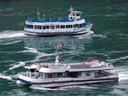 American tourist boat Maid Of The Mist, limited to 50 per cent occupancy under New York state's rules during the COVID-19 pandemic, moves past a Canadian vessel limited under Ontario's rules to just six passengers, in Niagara Falls, Ontario, July 21, 2020.