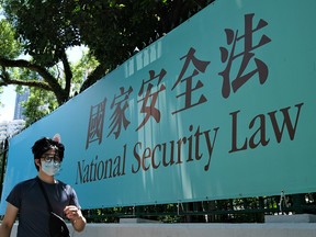 A man walks past a government notice banner for the National Security Law in Hong Kong on July 15, 2020.