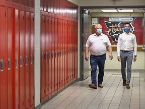 Ontario Premier Doug Ford, left, and Education Minister Stephen Lecce walk the hallway before making an announcement regarding the governments plan for a safe reopening of schools in the fall due to the COVID-19 pandemic at Father Leo J Austin Catholic Secondary School in Whitby, Ont., on Thursday, July 30, 2020.
