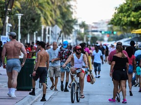 People walk and cycle on Ocean Drive in Miami Beach, Fla., on June 26, 2020. Florida recorded more than 12,600 new coronavirus cases on Monday, its second-highest daily total since the outbreak began.