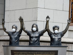 Surgical masks are placed on a statue outside of Princess Margaret Hospital in Toronto on March 19.