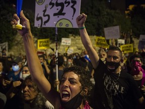 Protesters scream during a demonstration near Israeli Prime Minister Benjamin Netanyahu's residence in Jerusalem on July 14, 2020. Protesters were angered by the government's handling of the coronavirus pandemic and Netanyahu's indictment on corruption charges.