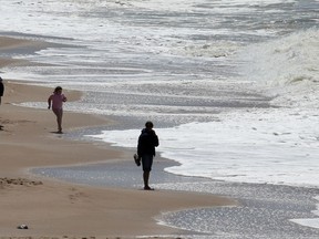 People walk along the beach by the Atlantic Ocean in Biarritz, southwestern France, Sunday, May 17, 2020. Canada is joining an international group of nearly two dozen other countries to push for protecting the world's oceans.