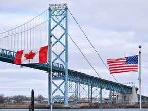 Canadian and American flags fly near the Ambassador Bridge at the Canada-USA border crossing in Windsor, Ont. on Saturday, March 21, 2020. Parents of students in the United States who hoped to begin their university studies in Canada are frantically trying to convince the federal government to relax new rules that make it impossible for their kids to enter the country.THE CANADIAN PRESS/Rob Gurdebeke