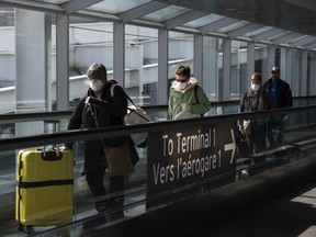 People leave the terminal after arriving at Pearson International Airport in Toronto on Monday, March 16, 2020. The federal government has extended the mandatory quarantine order for most people entering Canada until the end of August to help curb the spread of the novel coronavirus.