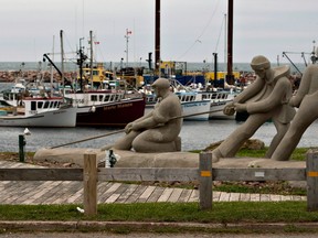A sculpture shows fishermen pulling on a line in front of the marina, Monday, August 6, 2012 in L'Étang du Nord on the Magdalen Islands. Quebecers traveling to the Iles-de-la-Madeleine this summer will not be able to stop in New Brunswick overnight, after restrictions on inter-provincial travel were tightened this week.