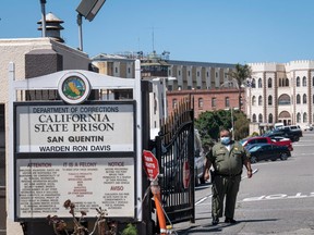 A California Department of Corrections and Rehabilitation (CDCR) officer wearing a protective mask stands at the front gate of San Quentin State Prison in San Quentin, California, U.S., on Tuesday, June 30, 2020.