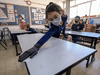 An Israeli student wearing protective gear sanitizes her desk upon return to school after the COVID-19 lockdown in Jerusalem, on May 3, 2020.