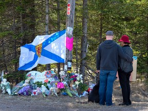A couple pays their respects at a roadblock in Portapique, N.S. on Wednesday, April 22, 2020. Premier Stephen McNeil says if panellists leading a review into Nova Scotia's recent mass shooting need more powers, he expects they will request them from his government.