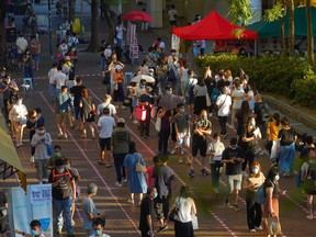 People queue up to vote in Hong Kong, Sunday, July 12, 2020, in an unofficial primary for pro-democracy candidates ahead of legislative elections in September.