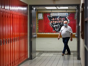 Ontario Premier Doug Ford walks the hallway before making an announcement regarding the government's plan for a safe reopening of schools in the fall, at Father Leo J Austin Catholic Secondary School in Whitby, Ont., on July 30.