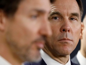 Former Minister of Finance Bill Morneau looks at Prime Minister Justin Trudeau during a press conference in Ottawa, Ont., on March 11, 2020.