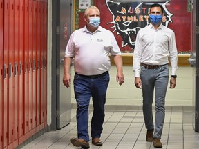 Ontario Premier Doug Ford, left, and Education Minister Stephen Lecce walk the hallway before making an announcement regarding the governments plan for a safe reopening of schools in the fall due to the COVID-19 pandemic at Father Leo J Austin Catholic Secondary School in Whitby, Ont., on Thursday, July 30, 2020.