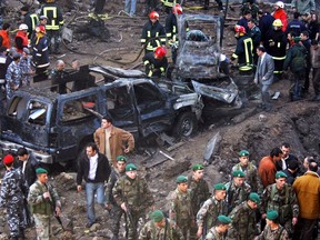 Vehicles destroyed in the bombing of the armed motorcade of former Lebanese Prime Minister Rafik al-Hariri, sit on a street Monday, February 14, 2005, in Beirut, Lebanon.