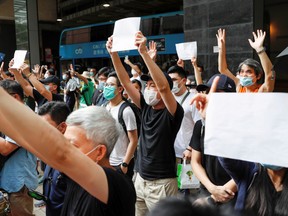 Supporters raise blank white paper to avoid slogans banned under the national security law as they support an arrested anti-law protester outside Eastern court in Hong Kong, China July 3, 2020.