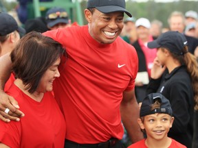 Tiger Woods of the United States celebrates with his son Charlie Axel as he comes off the 18th hole in honour of his win during the final round of the Masters at Augusta National Golf Club on April 14, 2019 in Augusta, Georgia.