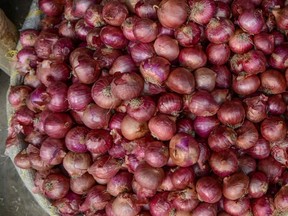 A vegetable seller sorts onions at a market in Siliguri on November 25, 2019.