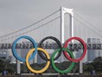 The Olympic rings are seen in front of Rainbow Bridge in Tokyo on Aug. 6, before being transferred back to the factory where they were manufactured for a safety inspection and to receive maintenance.