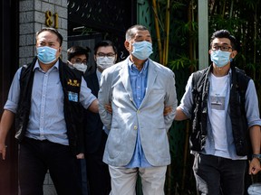 Police lead Hong kong pro-democracy media mogul Jimmy Lai away from his home after he was arrested under the new national security law in Hong kong