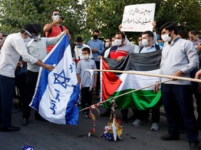 Iranian students set an Israeli and a U.S. flag on fire during a protest against a U.S.-brokered deal between Israel and the U.A.E. to normalize relations, in front of the U.A.E. embassy in the capital Tehran, on August 15 2020.