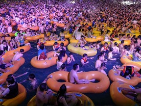 People pack together in a swimming pool at the Wuhan Maya Beach Water Park for a music festival in Wuhan in China's central Hubei province, August 15, 2020.