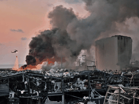 A helicopter puts out a fire at the scene of an explosion at the port of Lebanon's capital Beirut on August 4, 2020.