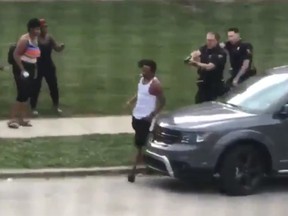 A still image from a video posted to Twitter shows police officers following Jacob Blake around his car in the moments before he is shot in the back multiple times in Kenosha, Wisconsin.