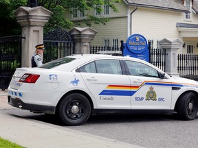 A police officer guards the front gate to Rideau Hall, and the grounds where Prime Minister Justin Trudeau lives, after an armed man was apprehended on the property, on July 2.