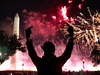 A protester gestures amid a fireworks show above the Washington Monument at the end of the Republican National Convention on August 27, 2020 in Washington, DC.