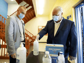 Ontario Premier Doug Ford, right, uses hand sanitizer as he gets a tour of Kensington Community School in Toronto from principal Dan Fisher to see the safety measures implemented as students return to school amidst the COVID-19 pandemic, on Tuesday, September 1, 2020.