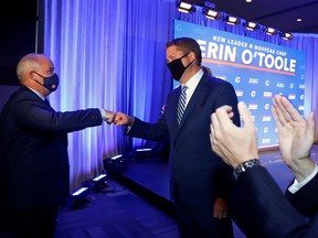 Erin O’Toole, newly-elected leader of the Conservative Party of Canada, left, fist bumps Andrew Scheer, the party's outgoing leader, in Ottawa on Aug. 24, 2020.