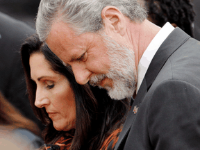 Jerry Falwell Jr. and his wife Becki bow their heads in a prayer after commencement ceremonies at Liberty University in Lynchburg, Virginia, May 11, 2019.