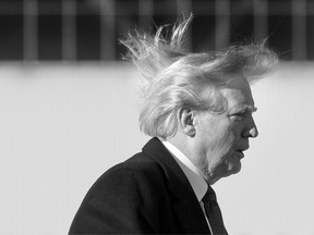 US President Donald Trump's hair blows in the wind as he boards Air Force One before flying to Vietnam to attend the annual Asia Pacific Economic Cooperation (APEC) summit at Beijing airport on November 10, 2017.