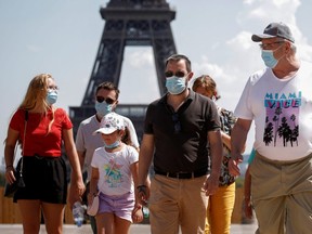 People wearing face masks walk at the Trocadero square near the Eiffel Tower in Paris as France reinforces mask-wearing as part of efforts to curb a resurgence of the coronavirus disease (COVID-19) across the country, August 9, 2020.