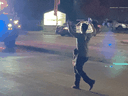 An armed person later identified as suspect Kyle Rittenhouse walks by police vehicles after fatal shootings at a protest in Wisconson, August 25, 2020.