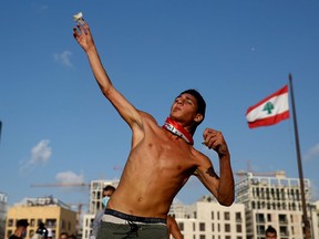 A demonstrator hurls stones during a protest following Tuesday's blast, in Beirut, Lebanon August 8, 2020.