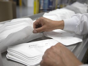 A worker collects N95 masks at a Medicom Inc. manufacturing facility in Montreal, on Aug. 20.