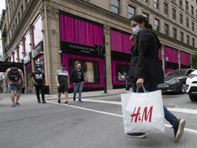 A pedestrian wearing a protective mask carries a Hennes&Mauritz H&M shopping bag in Montreal, Quebec