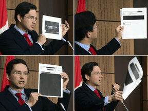 Conservative MP Pierre Poilievre holds up documents relating to the WE scandal  that were tabled by the government at the House of Commons finance committee, during a press conference on Wednesday, Aug. 19, 2020.