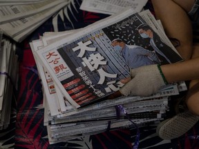 A vendor handles a copy of the Ta Kung Pao newspaper at a sorting area in Hong Kong, China, early on Tuesday, Aug. 11, 2020. Hong Kong police arrested Next Digital Ltd. Chairman Jimmy Lai and several of his top executives on Monday and sent hundreds of officers to search the Apple Daily newspaper's offices, a demonstration of the broad potential for the new national security law to silence criticism and dissent beyond pro-democracy protests and activism.