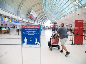 A man pushes a baggage cart wearing a mandatory face mask as a "Healthy Airport" initiative is launched for travel, taking into account social distancing protocols to slow the spread of the coronavirus disease (COVID-19) at Toronto Pearson International Airport in Toronto, Ontario, Canada June 23, 2020.