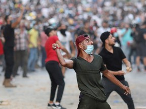 Demonstrators throw stones during a protest following Tuesday's blast in Beirut's port area, in Beirut, Lebanon, August 9, 2020.